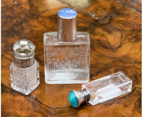 A silver and enamel topped glass scent bottle, blue guilloche enamel; together with two other silver and glass bottles (3) 
