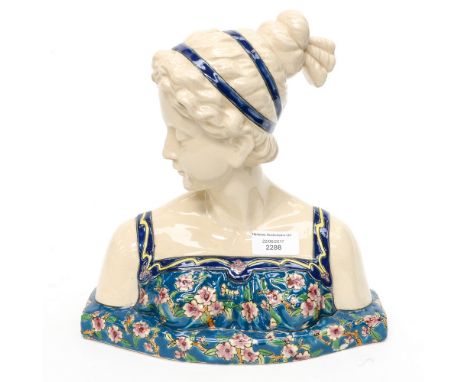 A Longwy style bust of a woman, in floral dress, French faience, 27cm high