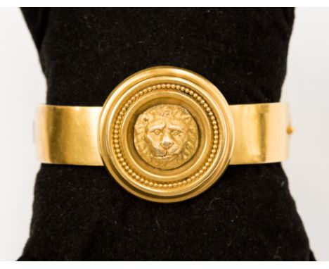 An 18ct stamped, circa 1850's regency style hinged bangle, with a circle detail complete with a lion head and grain edge. The