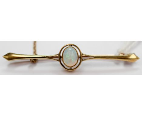 An Art Nouveau 15 carat gold and opal bar brooch, with a central set oval opal with mill grain setting. The brooch measures a