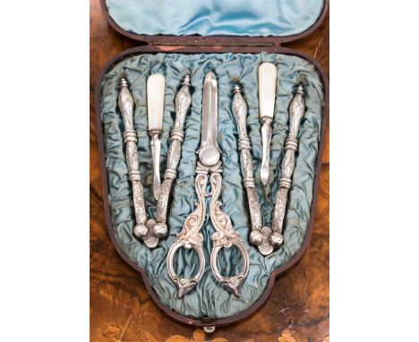 A cased set of white metal table grape scissors, nut crackers and mother of pearl handled scoops 