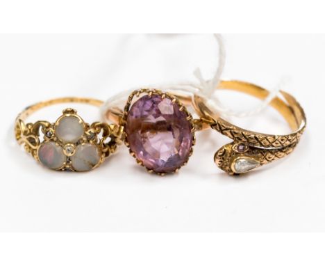 Three yellow metal rings, comprising of one three stone opal and diamond chip, one oval purple stone claw set ring, along wit