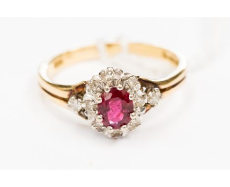 An oval ruby and diamond 18ct yellow gold cluster ring, the centre oval mixed cut ruby measuring approx 5.23 by 4.55 by 2.45 