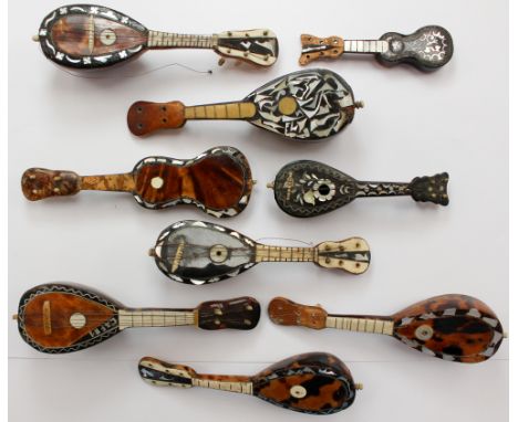 A bag of tortoise shell miniature Banjos and Guitars, some inlaid with mother of pearl (9) 