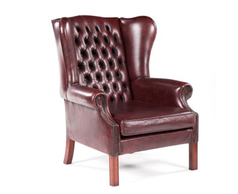 A CLOSENAILED LEATHER UPHOLSTERED WINGBACK ARMCHAIR MANUFACTURED BY GORDON FRASER the padded button-back between padded arms,