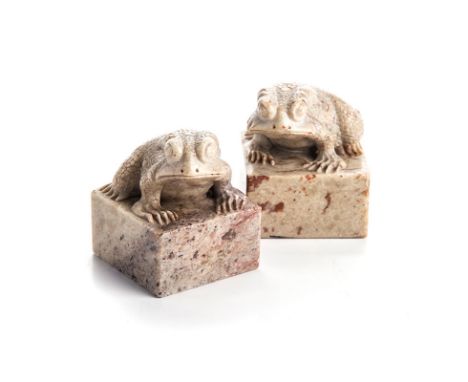 A PAIR OF CHINESE HARDSTONE TOAD SEALS each square seal surmounted with a toad, the stubby body carved with coarse skin and b