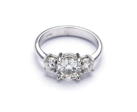 AN 18K WHITE GOLD TRILOGY RING centered with a 1.15ct round brilliant-cut diamond colour K clarity SI1 (Certified by IGI no 1