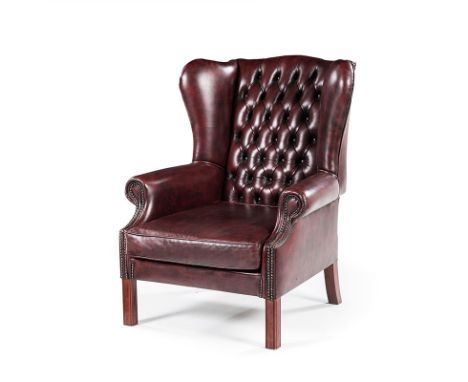 A CLOSENAILED LEATHER UPHOLSTERED WINGBACK ARMCHAIR MANUFACTURED BY GORDON FRASER the padded button-back between padded arms,