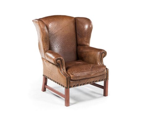 A CLOSENAILED OSTRICH LEATHER AND OAK WINGBACK ARMCHAIR the padded back and sides above a loose seat cushion, on square-secti