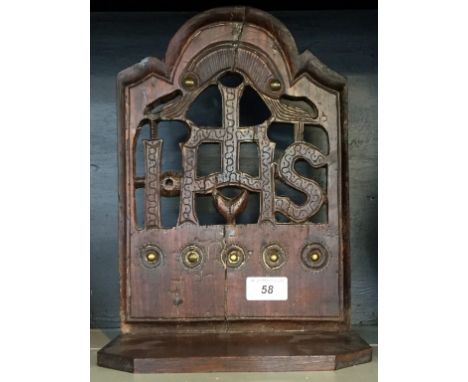 A 18th Century and later oak Religious hanging shelf entitled 'IHS' having brass applied and poker work style decorations, he