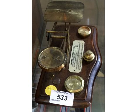 A set of brass metal postal scales complete with weights.