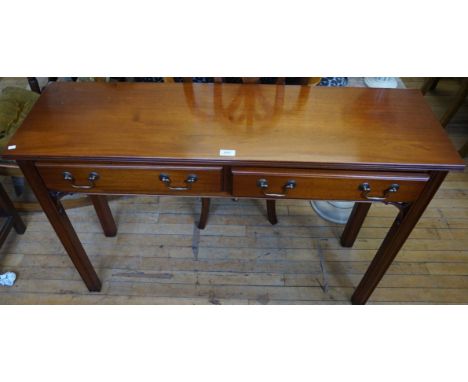 A good quality reproduction mahogany console table, having two single frieze drawers, raised on block supports.