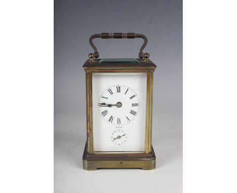 An early 20th century French brass cased carriage alarm clock with eight day movement striking on a bell, the enamelled dial 