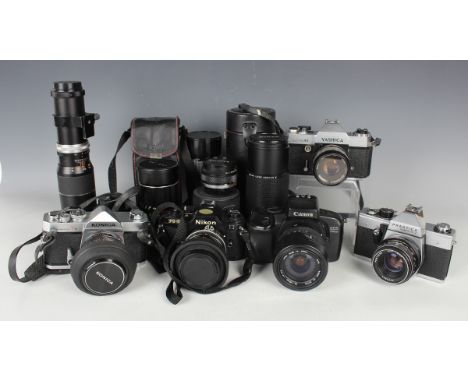 A collection of 35mm cameras and lenses, including Nikon FG-20 with Zoom-Nikkor 35-70mm lens, Canon EOS 750QD with Sigma 28-1