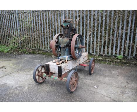 A Lister stationary engine. On metal chassis with wheels, complete with starting handle. Front axle requires attention