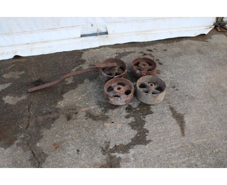 Four cast iron stationary engine wheels. In various sizes, one with axle, largest Diameter 23cm.