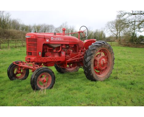 An International Harvester McCormick Farmall M tractor. BEB 680, 1949, in red, sold with V5, was running but has been stored 
