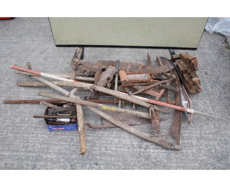 An assortment of vintage tools. Featuring scythes, hay knives plus two vices etc.