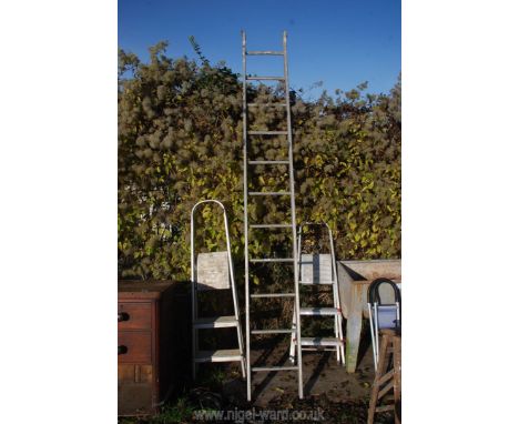 An eleven rung ladder and two pairs of step ladders.