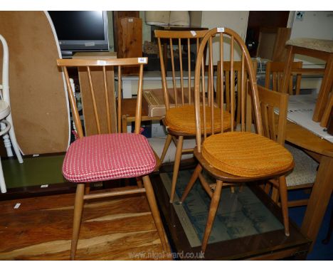 An Ercol kitchen chair and two Ercol dining chairs with seat pads.