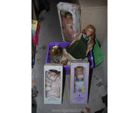A box of collectible dolls and brass scales.