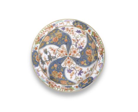 A Meissen deep dish, circa 1765Painted in underglaze-blue, enamels and gilding with a central floral motif of radiating panel