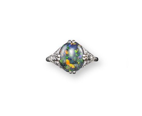 An early 20th century opal and diamond ring, the oval-shaped solid black opal is set in platinum with circular-cut and baguet