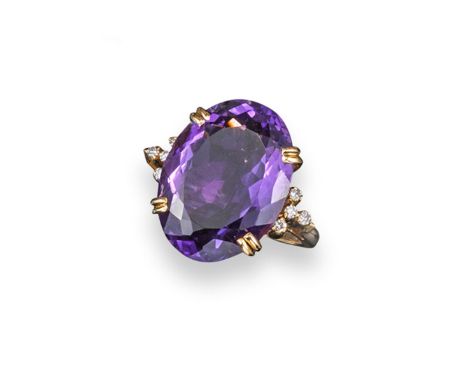An amethyst and diamond ring, the large oval-shaped amethyst with circular-cut diamond-set shoulders in yellow gold. Size P 1