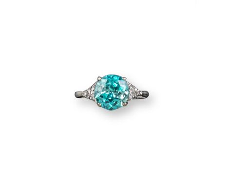 An Edwardian zircon and diamond ring, the circular cut blue zircon is set with twelve circular-cut shoulder diamonds in plati