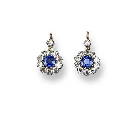 A pair of early 20th century, sapphire and diamond cluster earrings. The circular-cut sapphires are set within a surround of 