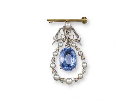 An Edwardian sapphire and pearl-set brooch pendant, the oval-shaped sapphire suspends from a diamond-set bow and a graduated 