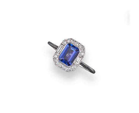 A tanzanite and diamond ring, the emerald-cut tanzanite is set within a surround of circular and baguette-shaped diamonds in 