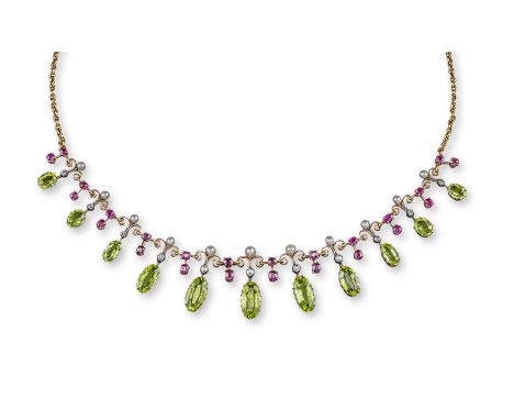 An Edwardian peridot fringe necklace, the graduated oval-shaped peridots suspend from a circular-cut diamond and seed pearl a