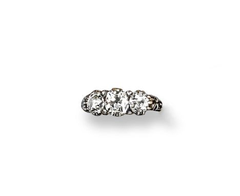 A three stone diamond ring, the three graduated old circular-cut diamonds are set in gold with engraved shoulders. Size M. 