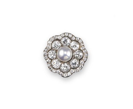 An Edwardian pearl and diamond brooch, of shaped circular form and centred with a button shaped pearl within a surround of ei