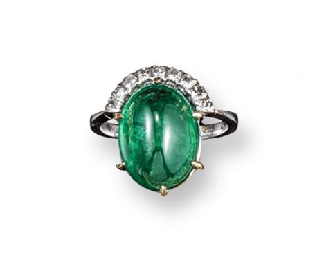 An emerald and diamond-set ring, the oval-shaped emerald cabochon is mounted in white gold with nine circular-cut diamonds. S