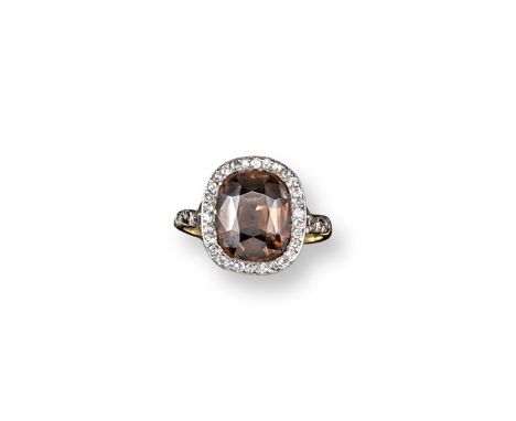 An early 20th century zircon and diamond cluster ring, the orange/brown cushion-shaped zircon is set within a surround of old