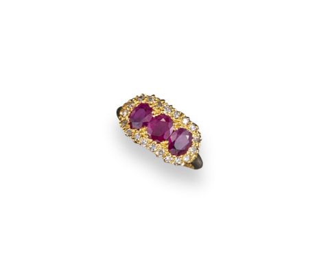 A ruby and diamond triple cluster ring, the oval-shaped rubies are set within a surround of small circular cut diamonds in go