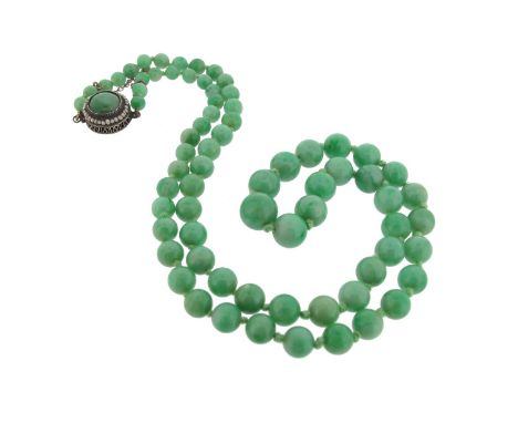 A jade bead necklace, the graduated beads measure 4.5 - 9.3mm, with cabochon jade and seed pearl cluster clasp with Chinese w