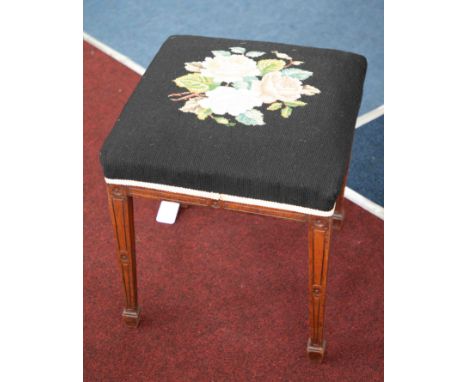 An early 20th Century mahogany framed stool on tapered legs with spade feet and tapestry upholstery.
