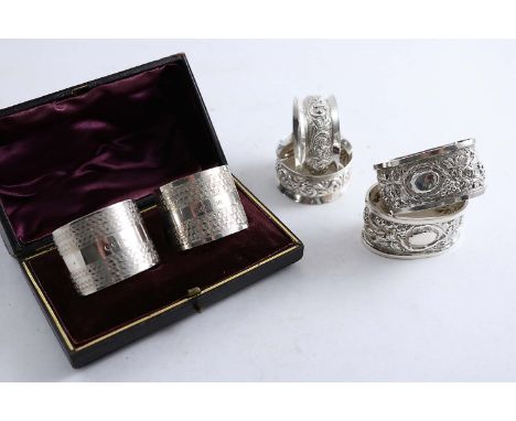 A CASED PAIR OF ENGINE-TURNED NAPKIN RINGS by E.J. Houlston, Birmingham 1920/21, a pair of Edwardian oval napkin rings chased
