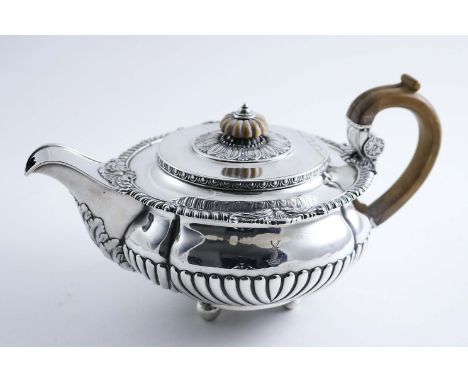 BY PAUL STORR:- A George III squat circular tea pot with part-fluting and ball feet, decorated around the rim with gadrooning