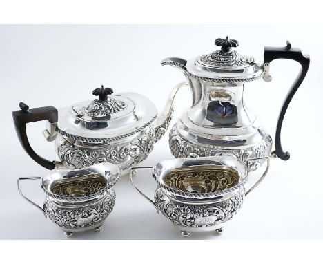 A LATE VICTORIAN / EDWARDIAN FOUR-PIECE TEA SERVICE with embossed decoration around the bodies, angular handles and button fe