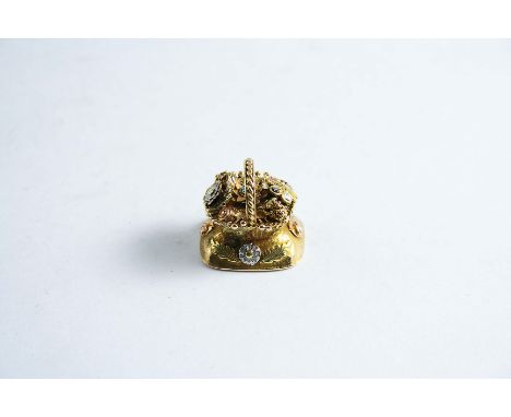 A THREE COLOUR GOLD AND GEM SET SEAL in the form of a basket of flowers, cornelian intaglio, engraved "Hurry up"; 2 cms