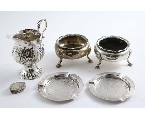 A MIXED LOT:- A George III cream jug chased with pastoral scenes, a pair of Victorian circular salts, a pair of engine-turned