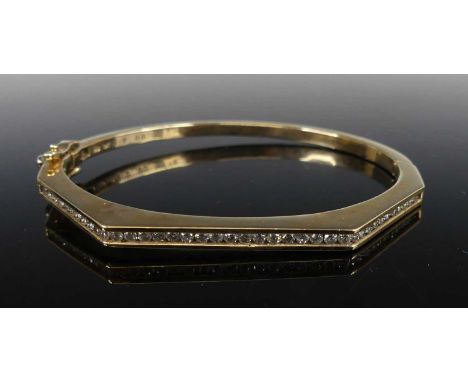 A 9ct yellow gold diamond hinged bangle, having angled front section channel set with 39 round brilliant cut diamonds, with b