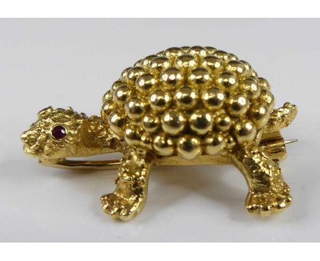 An 18ct yellow gold three-dimensional tortoise brooch, having beaded detail to the shell and two 1.7mm round red stone eyes, 