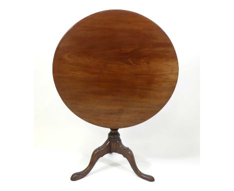 A George III mahogany pedestal tripod table, having a one-piece circular tilt-top over a baluster turned column, on three hip