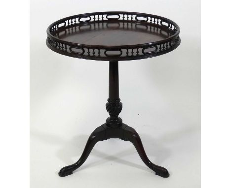 A George III mahogany pedestal tripod table, the circular tilt-top (split) having a full arcaded gallery, all above a gun bar