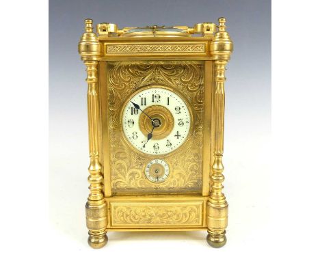 A late 19th century lacquered brass quarter repeating carriage clock with alarm, the case having proud turned and fluted pila
